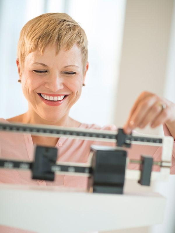 woman weighing herself on a doctor scale